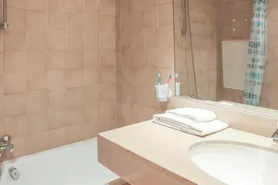a bathroom with a sink and a tub and a shower at Résidence Partenaire Le Palais de la Marine in Villefranche-sur-Mer
