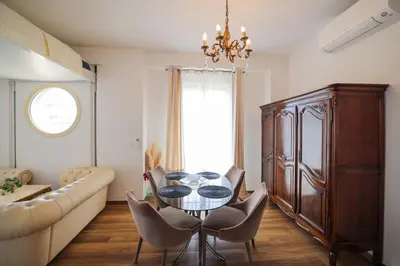 a living room with a table and chairs and a couch at Appartement Gare Nice Ville in Nice