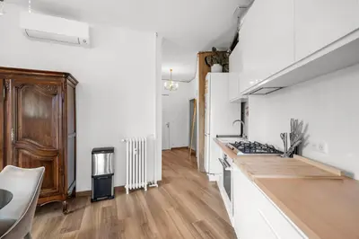 a kitchen with white walls and a wooden counter top at Appartement Gare Nice Ville in Nice