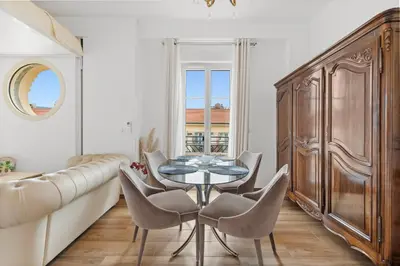 a dining room with a table and chairs and a couch at Appartement Gare Nice Ville in Nice