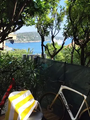 a bike parked next to a fence with a view of the ocean at Studio avec grande terrasse YourHostHelper in Villefranche-sur-Mer