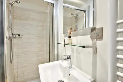 a white bathroom with a sink and a shower at Studio avec grande terrasse YourHostHelper in Villefranche-sur-Mer