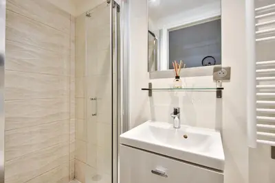 a white bathroom with a sink and a shower at Studio avec grande terrasse YourHostHelper in Villefranche-sur-Mer
