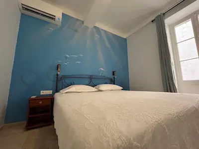 a bedroom with a bed with a blue wall at Rossetti Rosa Vieux Nice 2 bed in Nice