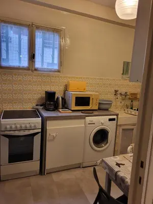 a kitchen with a microwave and a washing machine at 2 pieces pour 4 personnes proche tram in Nice