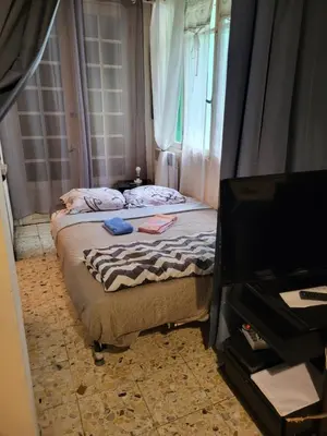 two beds in a room with a television at 2 pieces pour 4 personnes proche tram in Nice