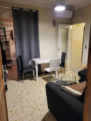 a room with a table and chairs and a black curtain at 2 pieces pour 4 personnes proche tram in Nice