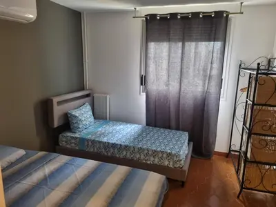 a bedroom with two beds and a window at F2 ou F3 ,appartement climatisé neuf, magnifique vue sur mer et aéroport, proche tram et gare sncf 1 min,aéroport 3 minutes, 3 rooms, new AC apartment, magnificent sea and airport views, close to tram and SNCF train station 1 min, airport 3 min in Nice