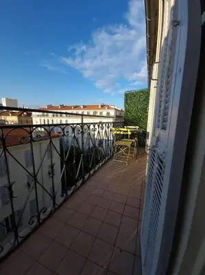 a balcony with a table and chairs on a building at Appt 2 pièces 43 Avenue Jean Médecin in Nice