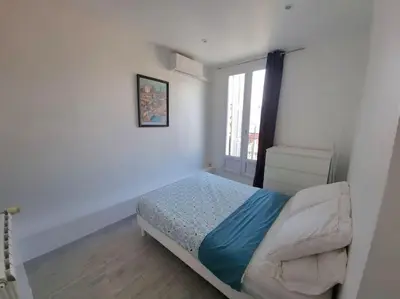 a small bedroom with a bed and a window at Appt 2 pièces 43 Avenue Jean Médecin in Nice