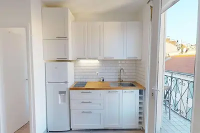 a white kitchen with a sink and a refrigerator at Appt 2 pièces 43 Avenue Jean Médecin in Nice