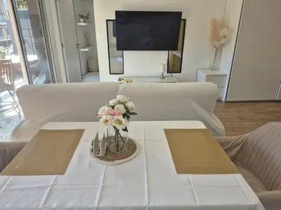 a white table with a vase of flowers on it at Superbe Appartement Luxueux Spacieux 50 m2 Port Nice in Nice