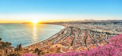 a view of a city and the ocean at sunset at Appartement Nice centre ville gare in Nice