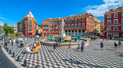 a group of people walking around a fountain in a city at Appartement Nice centre ville gare in Nice