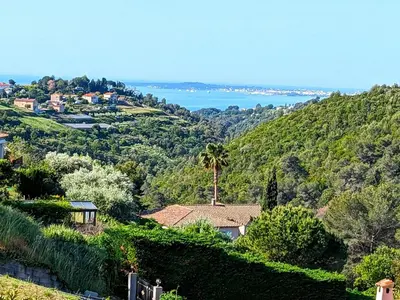 a house on a hill with the ocean in the background at CASA-Mathilda luxueuse villa moderne avec piscine in La Gaude