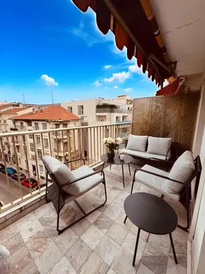 a balcony with couches and tables and a view of a city at Residence Butterfly in Nice