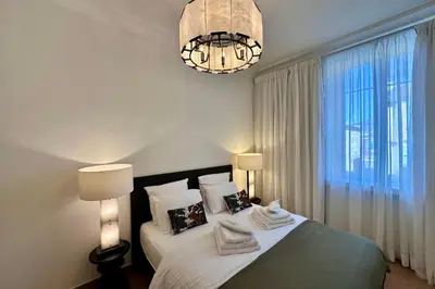 a bedroom with a bed with two lamps and a chandelier at QUAI PROMENADE VIEW Sea View Balcony 3 Bedrooms Air Conditioning in Nice