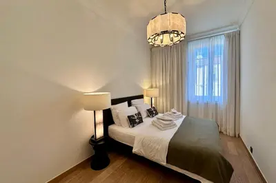 a bedroom with a bed with two lamps and a window at QUAI PROMENADE VIEW Sea View Balcony 3 Bedrooms Air Conditioning in Nice