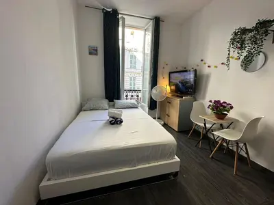 a bedroom with a white bed and a window at Delight room 1st door in Nice