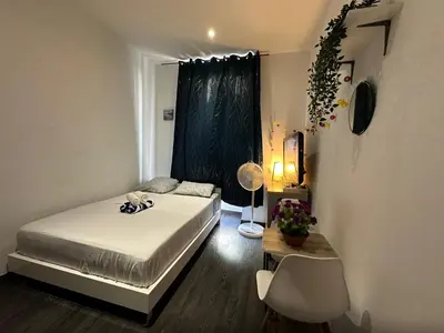 a bedroom with a bed and a table and a window at Delight room 1st door in Nice