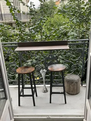 a table and two stools on a balcony at Spacieux 4 couchage plein centre in Nice