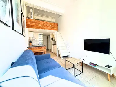 a living room with a blue couch and a tv at Cosy appart 4pers vieux Nice in Nice