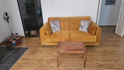 a brown couch sitting in a living room with a coffee table at 68 m2 central pour des vacances en famille in Nice