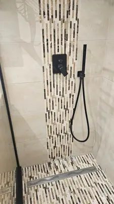 a shower with a shower head in a bathroom at 68 m2 central pour des vacances en famille in Nice