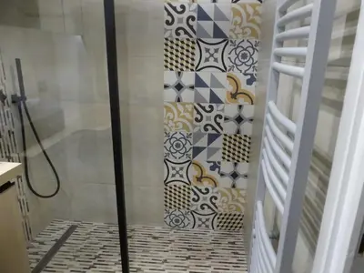 a shower in a bathroom with tiles on the wall at 68 m2 central pour des vacances en famille in Nice