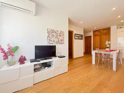 a living room with a television on a white cabinet at Suite Zara - wifi, AC, 4 pers in Nice
