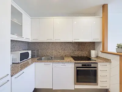 a kitchen with white cabinets and a sink and a microwave at Suite Zara - wifi, AC, 4 pers in Nice