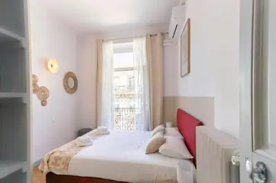 a bedroom with a white bed and a window at #57 Suite Notre Dame Central balcony & AC in Nice