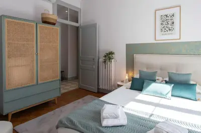 a bedroom with a large bed with blue accents at #57 Suite Notre Dame Central balcony & AC in Nice