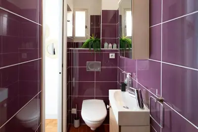 a purple bathroom with a toilet and a sink at #57 Suite Notre Dame Central balcony & AC in Nice