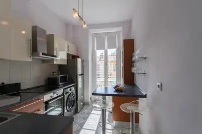 a kitchen with a black counter top and a refrigerator at #57 Suite Notre Dame Central balcony & AC in Nice