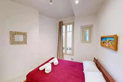a bedroom with a red bed with towels on it at Bright air-conditioned flat in the city centre in Nice