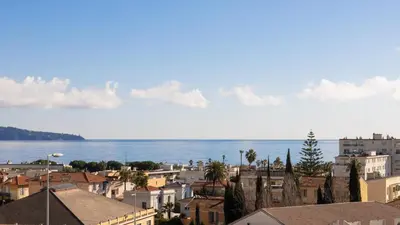 a city with buildings and the ocean in the background at Vue mer sublime, terrasse ensoleillée et parking in Nice