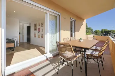 a patio with a table and chairs on a balcony at Vue mer sublime, terrasse ensoleillée et parking in Nice