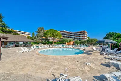 a swimming pool with lounge chairs and a resort at Superbe 2 pièces Clim et Parking in Nice