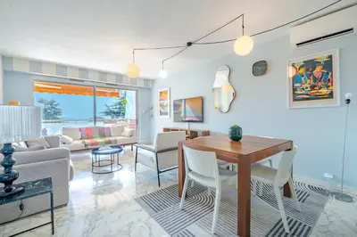 a living room with a table and a couch at Superbe 2 pièces Clim et Parking in Nice
