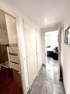 a hallway with white cabinets and a living room at Ze Perfect Place - Studio centre-ville - Masséna in Nice