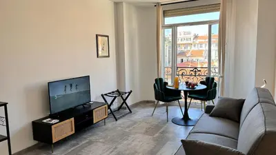 a living room with a couch and a tv and a table at Ze Perfect Place - Studio centre-ville - Masséna in Nice