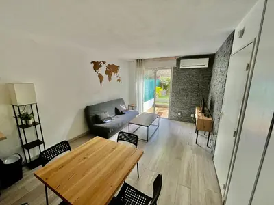 a living room with a table and a couch at Le Rieviera Bay-Parking-Jardin Pick up Airport in Saint-Laurent-du-Var