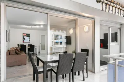 a dining room and living room with a table and chairs at Suite Prestige FSHH in Nice