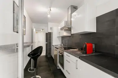 a kitchen with white cabinets and a red appliance at Suite Prestige FSHH in Nice