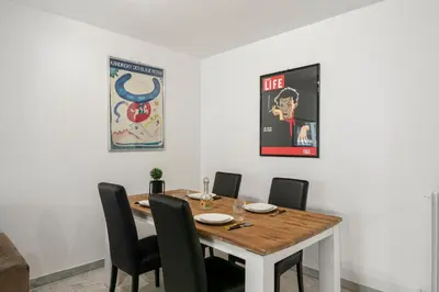 a dining room with a wooden table and chairs at Suite Prestige FSHH in Nice
