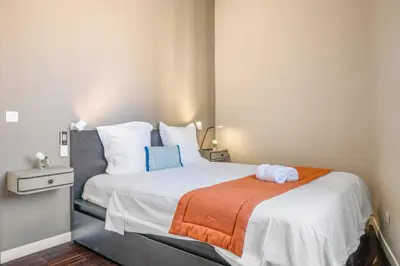 a bedroom with a large white bed with an orange blanket at Sunlight Properties - Capitaine 54 - 1 Bedroom, stunning holiday rental apartment with balcony and port view in Nice