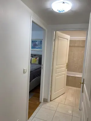a bedroom with a bed and a door to a bathroom at Le Grand Palais de la Méditerranée Beach Access Apartments - Top Choice In Nice in Nice