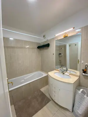 a bathroom with a tub and a sink and a mirror at Le Grand Palais de la Méditerranée Beach Access Apartments - Top Choice In Nice in Nice
