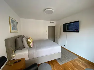 a bedroom with a bed and a tv on the wall at Le Grand Palais de la Méditerranée Beach Access Apartments - Top Choice In Nice in Nice